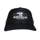 BCN Classic Trucker Curved Hat in black with hexagonal 3D PVC patch — raised white Blue Collar Nutrition logo on black rubberized background, front view