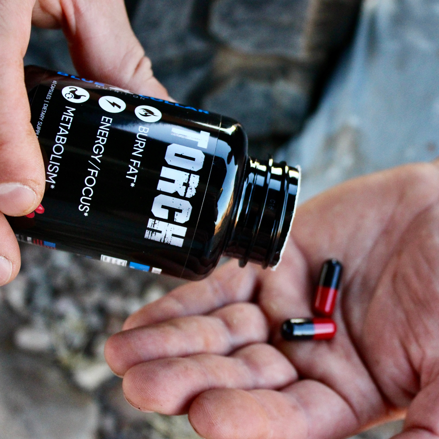 TORCH thermogenic capsules being poured from bottle on workshop bench